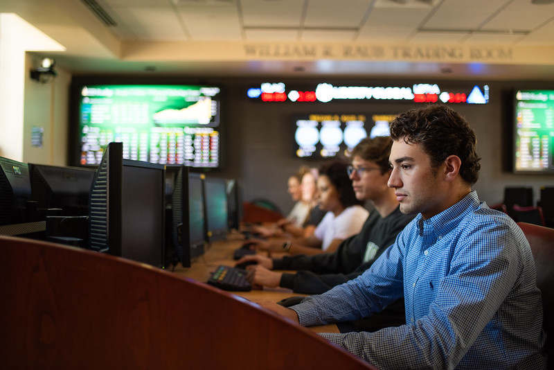 student in trading room at computer