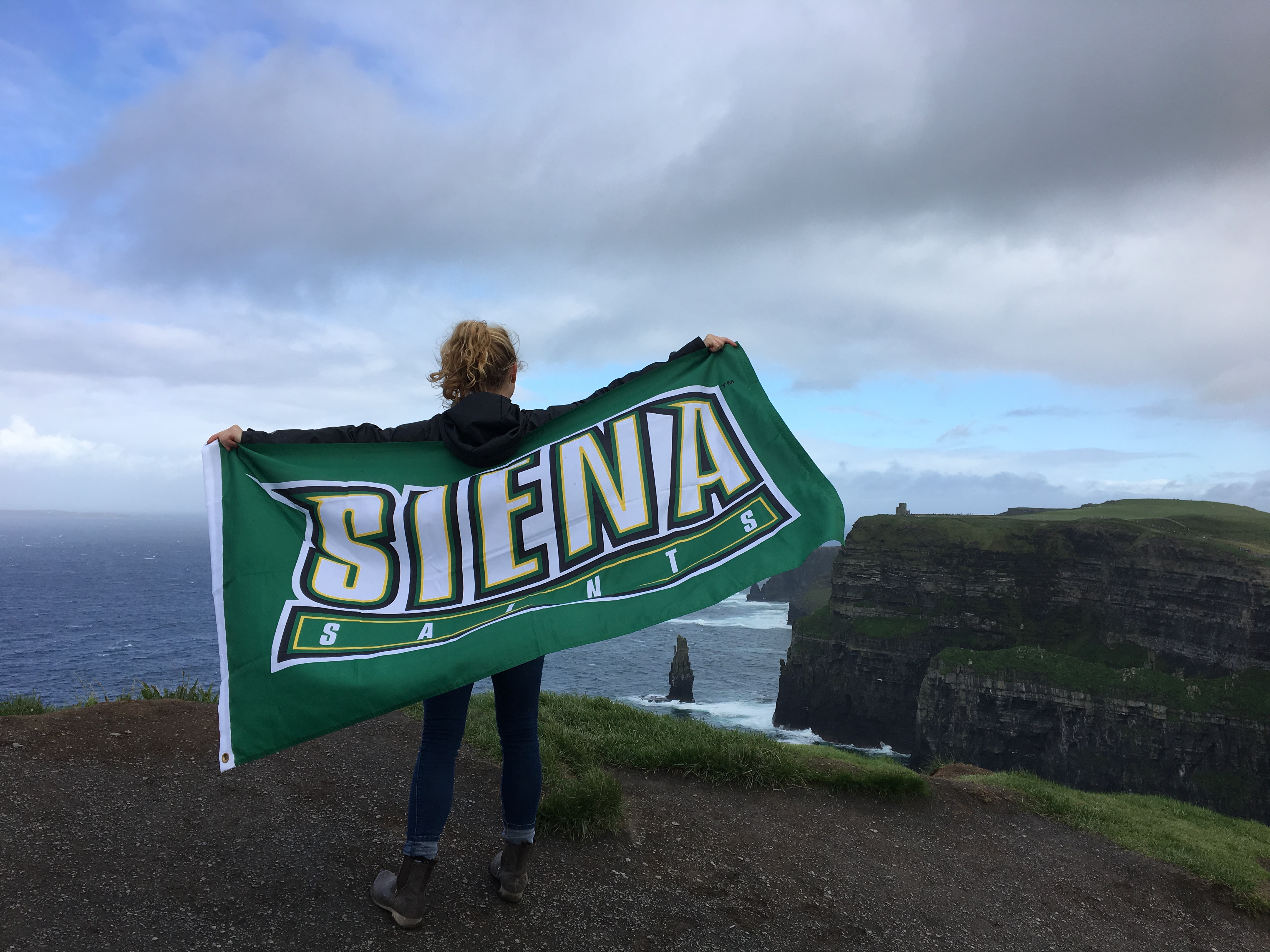 Student stands on the cliffs of mohr in ireland
