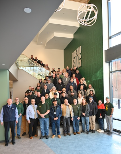 Facilities team lined up on the stairs of Nobel Hall for a photo